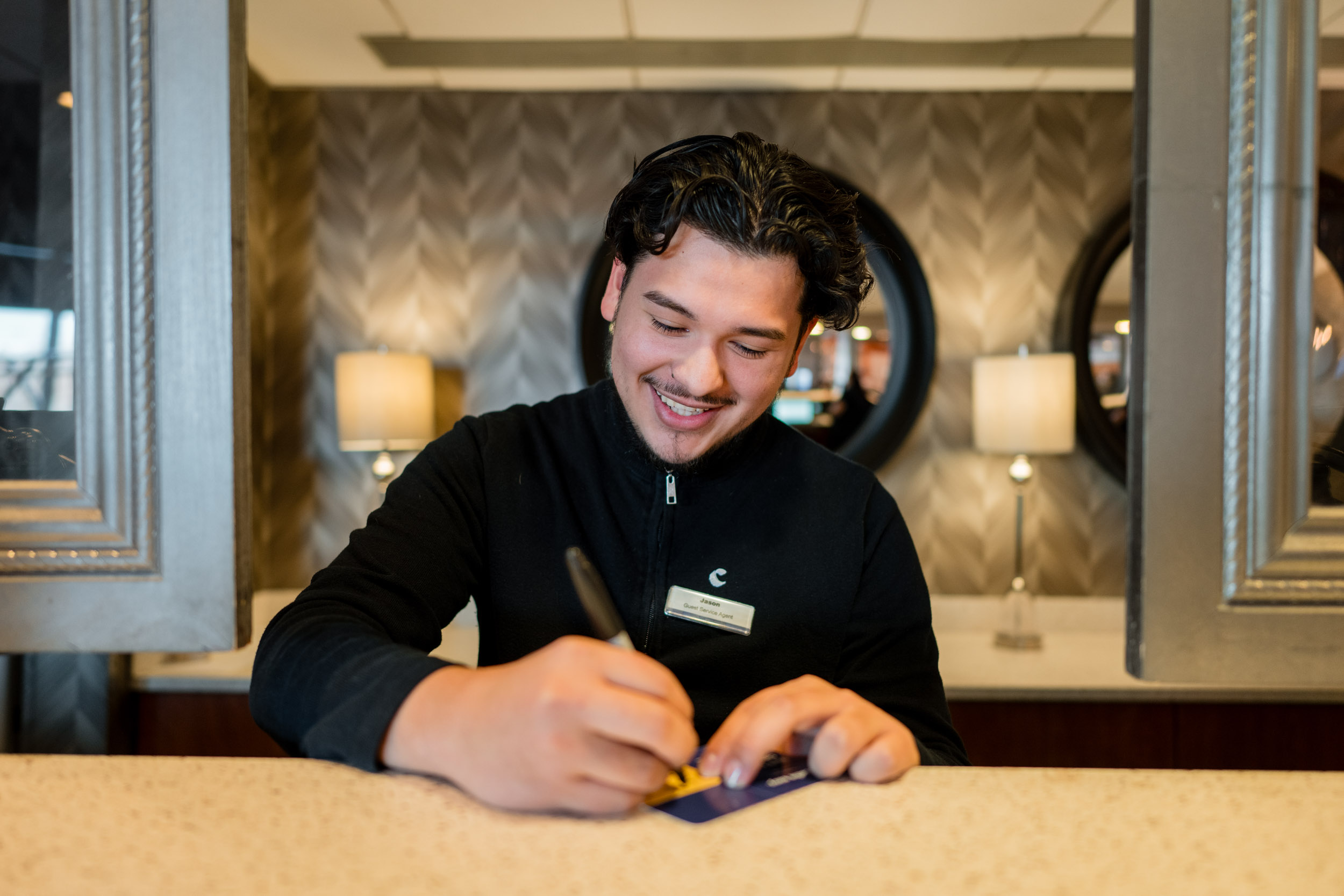 Comfort Inn & Suites Logan International Airport front desk staff member checking in a guest